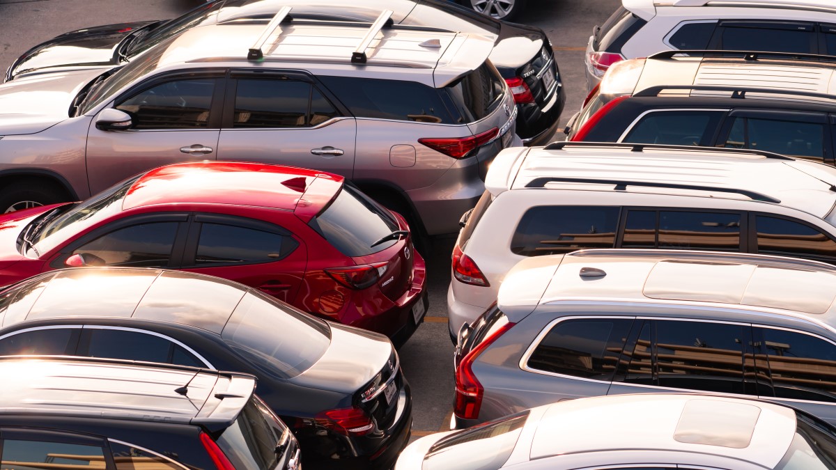 Person inspecting a used car at a lot