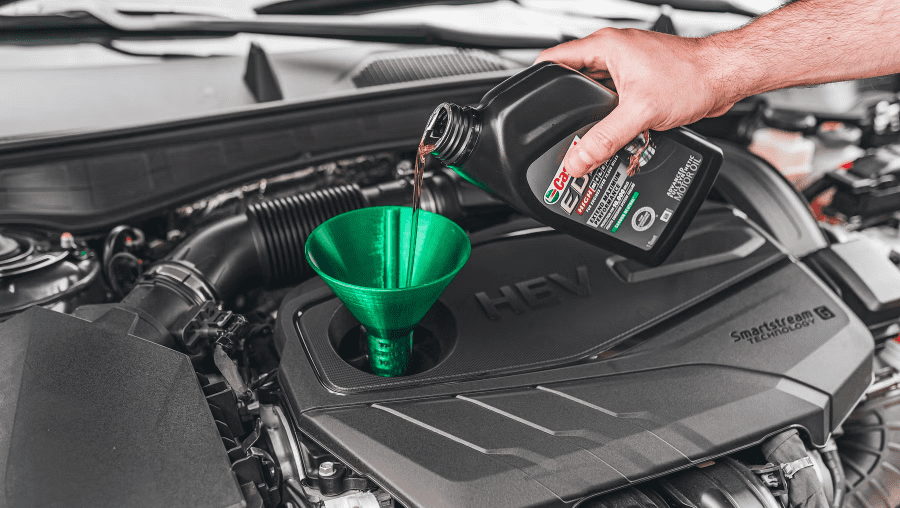 Mechanic changing engine oil in modern car
